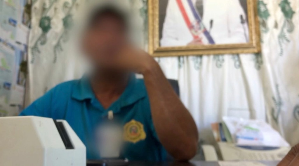 Photo of a man at a desk in the immigration office